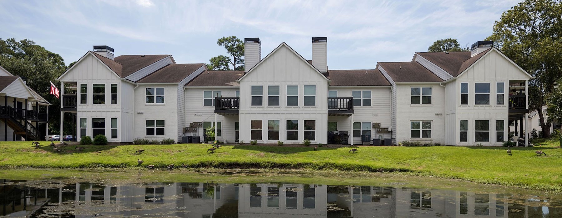 a row of houses next to a pond