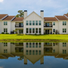 a row of houses next to a pond